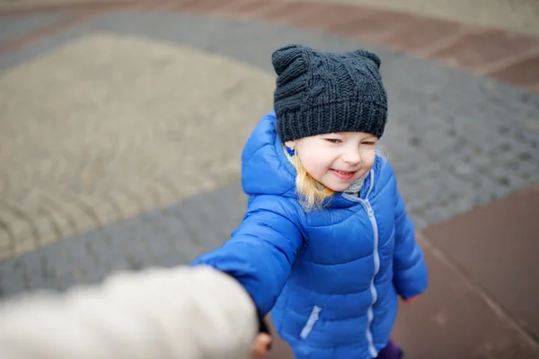 Meisje die haar moeders hand — Stockfoto