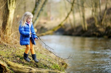 Kız bir nehir tarafından sopayla oynamaktan