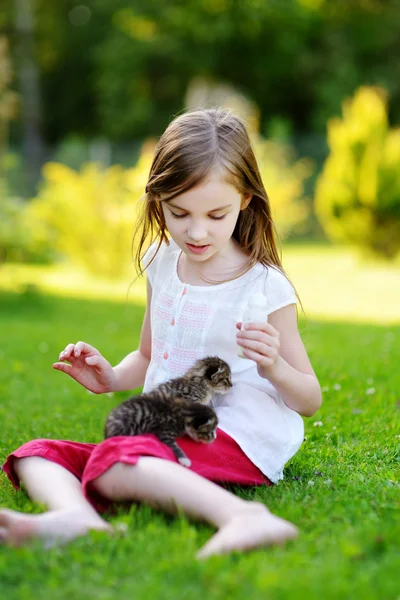 Kleines Mädchen füttert kleine Kätzchen — Stockfoto