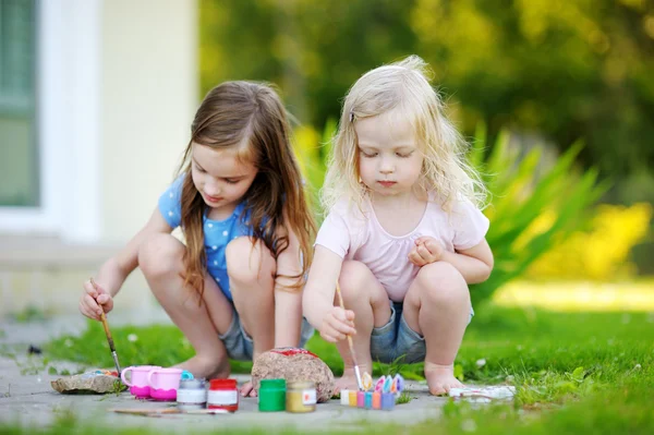 Kleine Schwestern malen auf Steinen — Stockfoto
