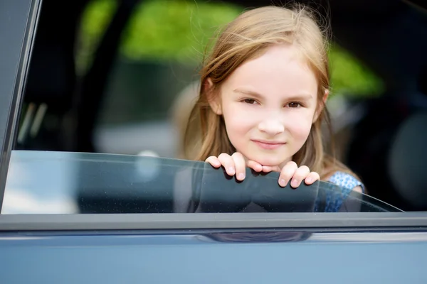 Meisje steekt haar hoofd uit de auto — Stockfoto