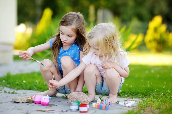 Little sisters painting on stones — Stock Photo, Image