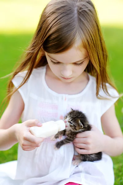 Little girl feeding small kitten — Stock Photo, Image