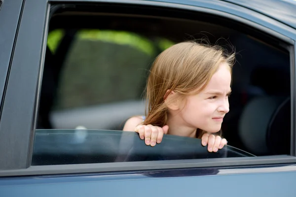 Meisje steekt haar hoofd uit de auto — Stockfoto