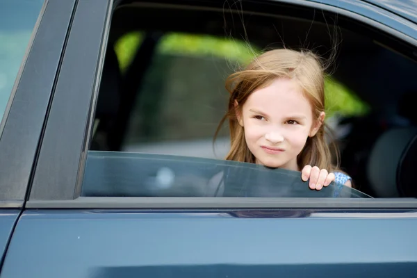 Meisje steekt haar hoofd uit de auto — Stockfoto