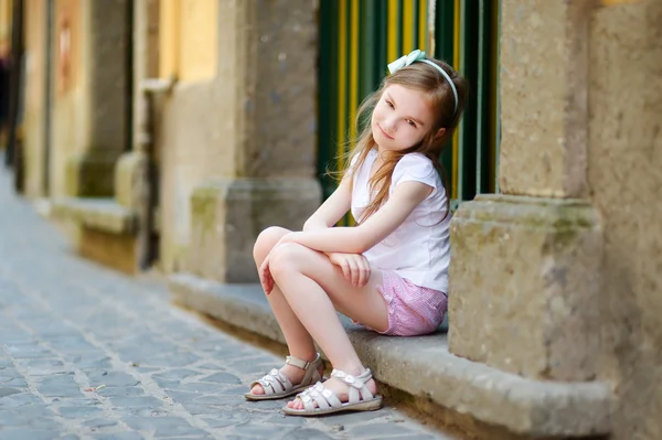 Kapının önünde oturan küçük kız — Stok fotoğraf