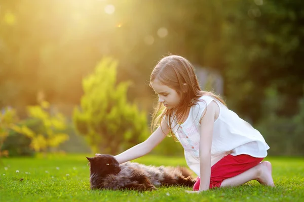 Kleines Mädchen streichelt schwarze Katze — Stockfoto