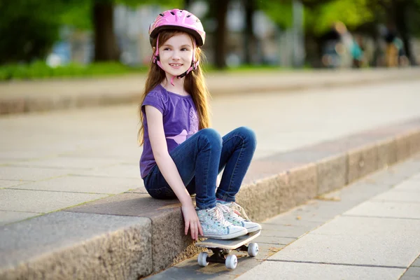 Kleines Mädchen sitzt auf einem Skateboard — Stockfoto