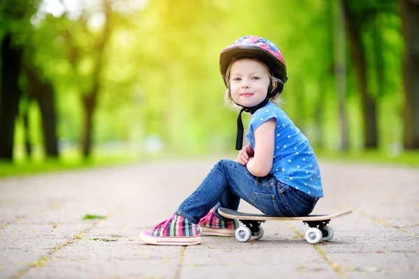 Μικρό κορίτσι που κάθεται σε ένα skateboard — Φωτογραφία Αρχείου