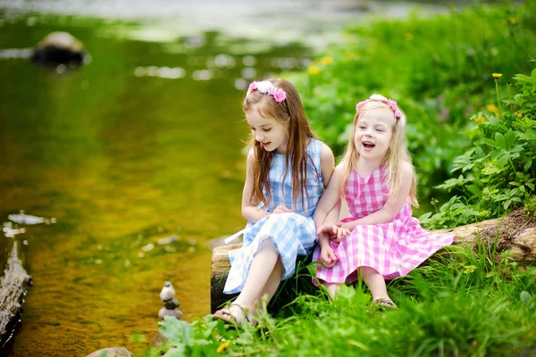 Two little sisters playing by a river — Stock Photo, Image