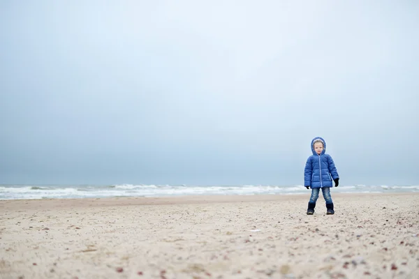 Pieni tyttö leikkii meren rannalla — kuvapankkivalokuva