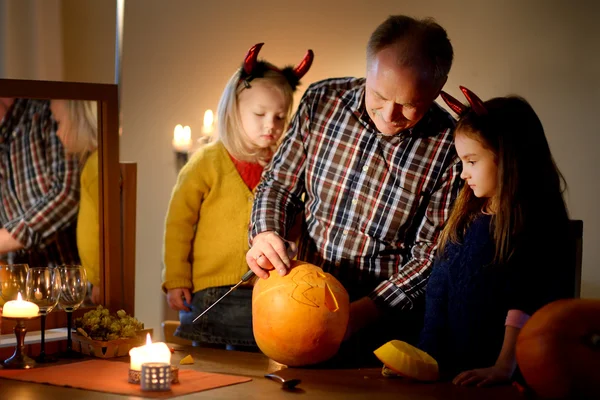Sisters and their grandpa carving a pumpkin — Stock Photo, Image
