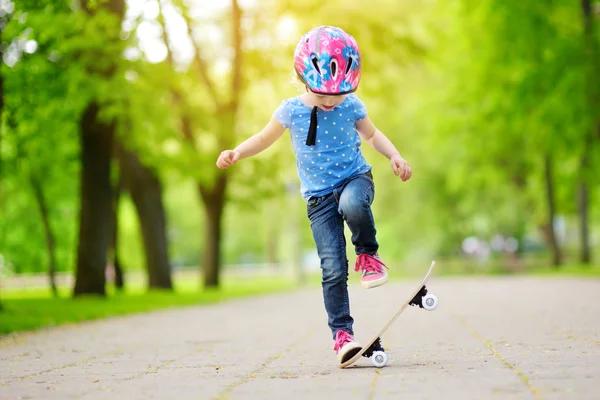 Маленька дівчинка вчиться скейтборді на відкритому повітрі — стокове фото