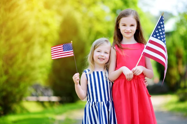 Hermanitas sosteniendo banderas americanas — Foto de Stock