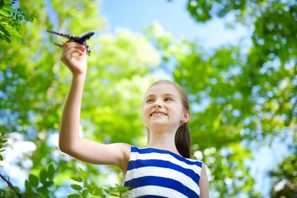 Little girl playing with toy airplane — Stock Photo, Image