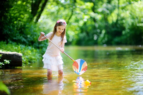 Niedliches kleines Mädchen spielt in einem Fluss — Stockfoto