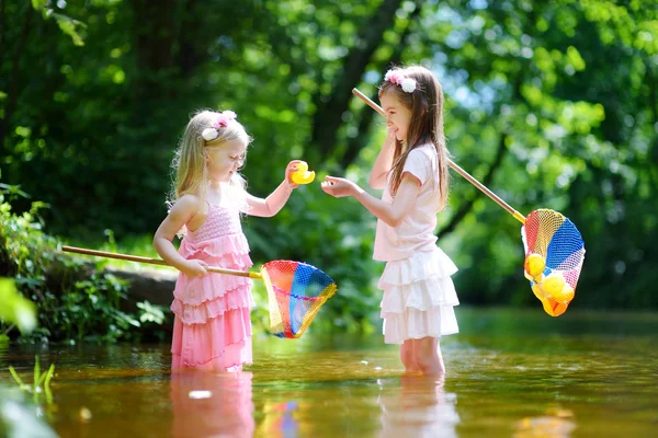 Two little sisters playing in a river — Stock Photo, Image