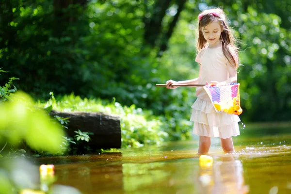 Милая маленькая девочка, играющая в реке — стоковое фото