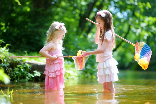 Two little sisters playing in a river — Stock Photo, Image