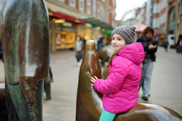 Bonito turista sentado na escultura — Fotografia de Stock