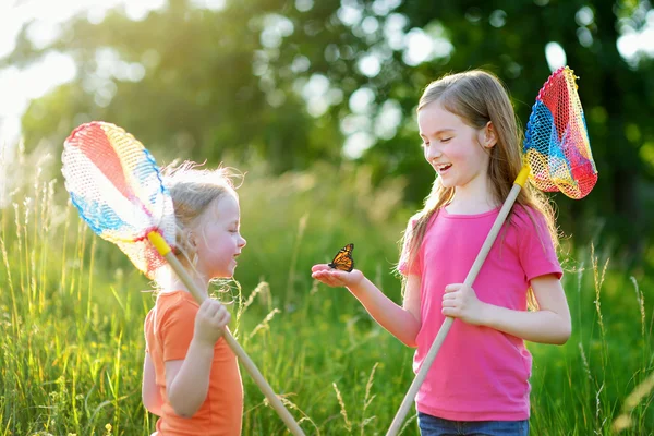 Girls catching butterfly — Stock Photo, Image