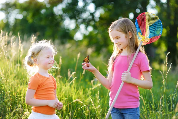 Girls catching butterfly — Stock Photo, Image