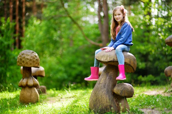 Menina se divertindo no cogumelo de madeira — Fotografia de Stock