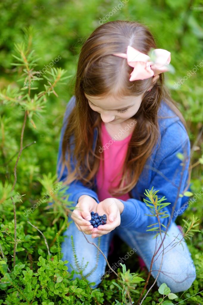 Girl picking blueberries — Stock Photo © MNStudio 116691328