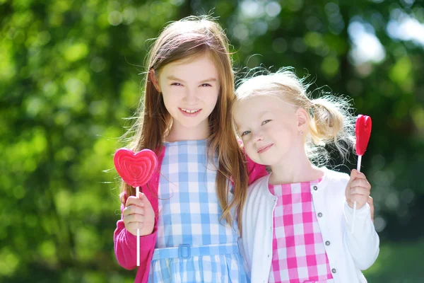 Hermanas pequeñas con piruletas — Foto de Stock