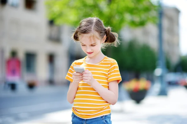 Симпатичная девушка играет в мобильную игру — стоковое фото