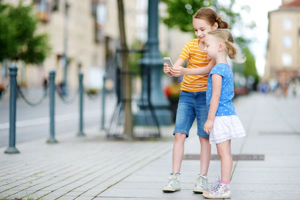 Hermanas jugando al aire libre móvil juego — Foto de Stock