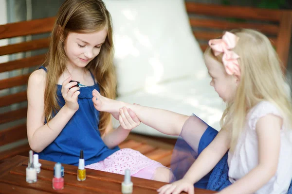 Adorable little girls painting nails — Stock Photo, Image