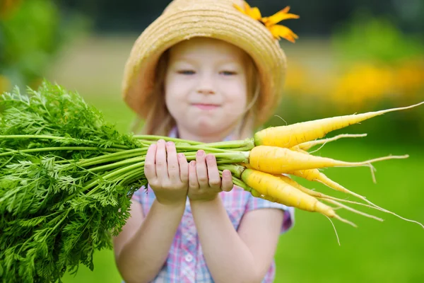 Linda chica sosteniendo zanahorias amarillas — Foto de Stock