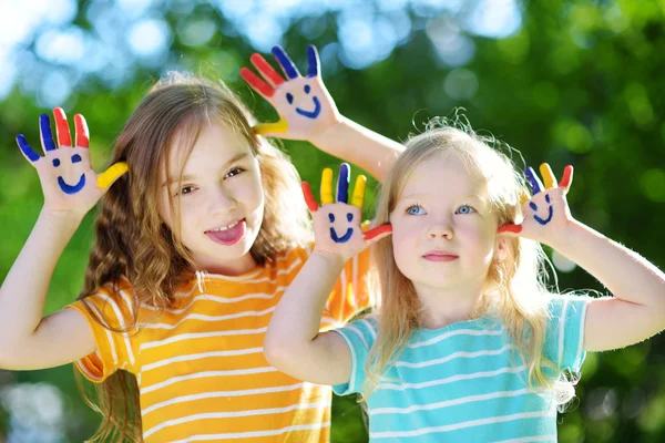 Adorable little sisters with painted hands — Stock Photo, Image