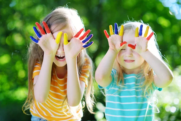 Adorable little sisters with painted hands — Stock Photo, Image