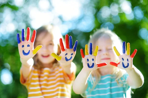 Adorable little sisters with painted hands — Stock Photo, Image