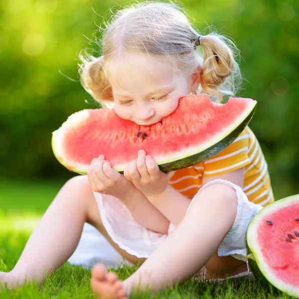 Funny little girl biting watermelon — Stock Photo, Image