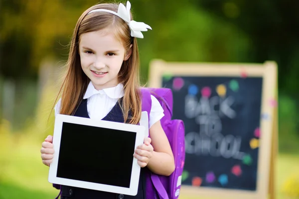 Adorable écolière tenant tablette numérique — Photo