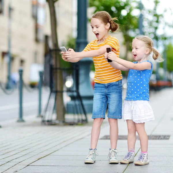Little sisters mobil oyun oynuyor — Stok fotoğraf