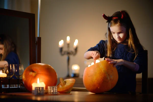 Adorable petite fille avec citrouille sculptée — Photo