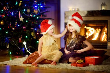  Noel'de bir şöminenin yanında oynayan kız