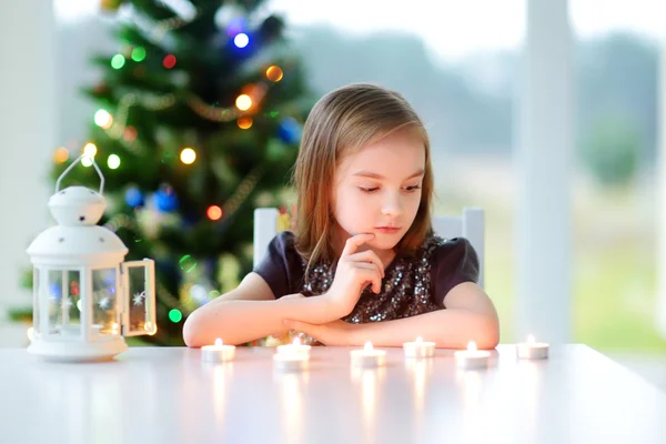 Beautiful little girl lighting a candles — Stock Photo, Image