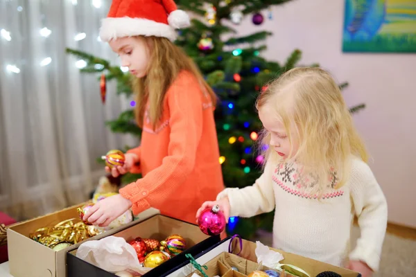 Nővérek díszíti a karácsonyfát — Stock Fotó