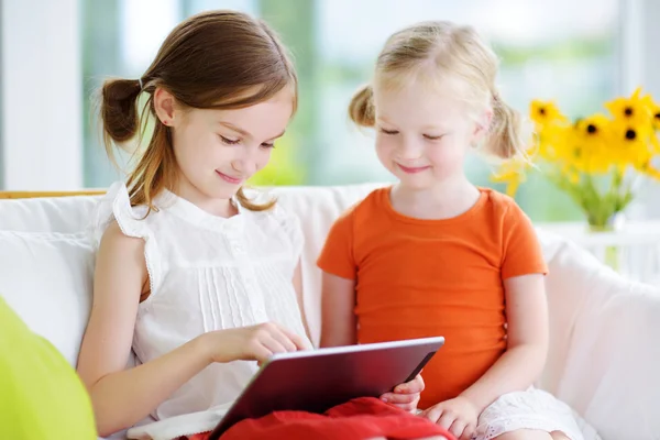 Systrarna leker med en digital tablet — Stockfoto
