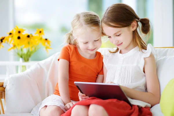 Sisters playing with a digital tablet — Stock Photo, Image