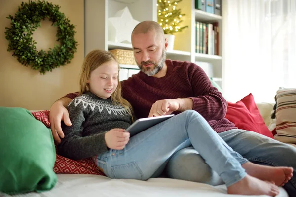 爸爸和他的女儿在圣诞节的时候有网上视频通话 大流行期间与远方的家人聊天 寒假期间保持安全 用现代小玩意庆祝圣诞节 — 图库照片