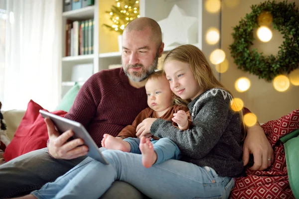 爸爸和他的孩子在圣诞节的时候有网上视频通话 大流行期间与远方的家人聊天 寒假期间保持安全 用现代小玩意庆祝圣诞节 — 图库照片