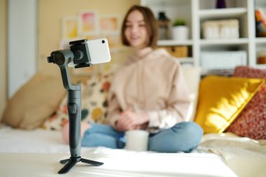Güzel genç kız akıllı telefonuyla video blogu kaydediyor. Evde video blogu çeken genç bir vlogger. Genç nüfuzlu biri sosyal medya hesabı için içerik yaratıyor. Sosyal medya ve günlük tutma kavramı.