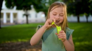 Gün batımında sabun köpüğü üfleyen güzel genç kız.