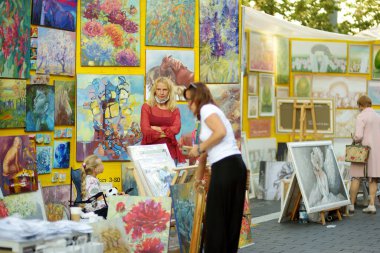 VILNIUS, LITHUANIA - 5 Eylül 2020: Litvanya ulusal topluluklarından ustaların sanatlarını, zanaatlarını, geleneklerini ve geleneklerini sundukları Uluslar Fuarı 'nda resimlerini satan sanatçılar.